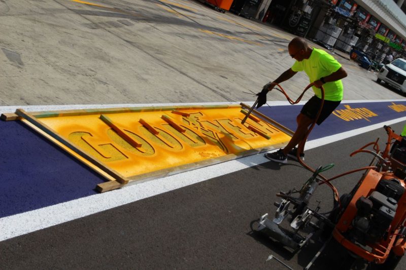 A man paints a Goodyear sign at the 2024 Prologue in the FIA World Endurance Championship
