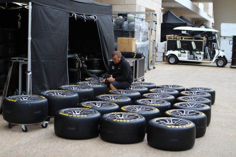 A man checks tyre pressures at the 2024 Prologue in the FIA World Endurance Championship